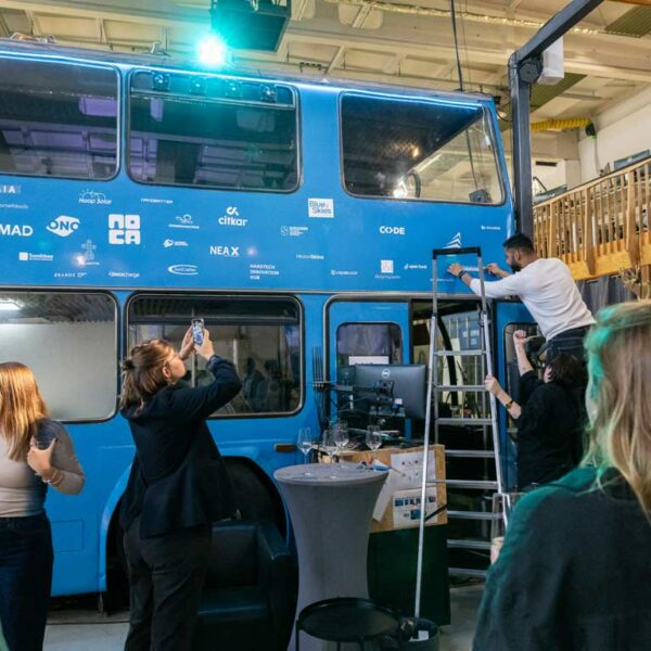 Some startups and ecosystem partners putting their logos on our iconic blue bus next to the stage in our eventlocation Berlin.